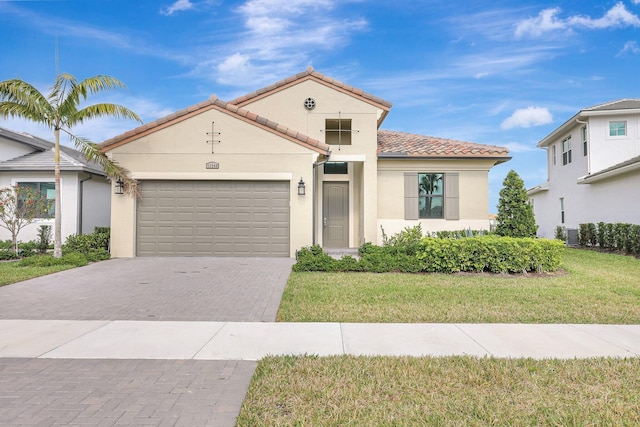 mediterranean / spanish house featuring a garage and a front lawn