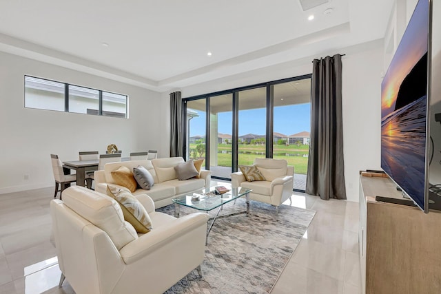 living room featuring light tile patterned floors and a raised ceiling