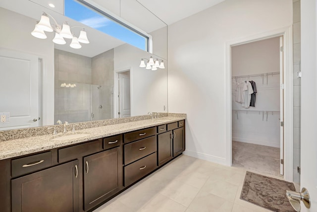 bathroom featuring vanity, a shower with shower door, tile patterned flooring, and a notable chandelier