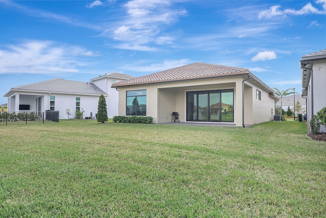 rear view of house featuring cooling unit and a lawn