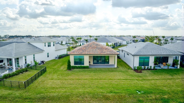 rear view of property featuring a lawn and a patio