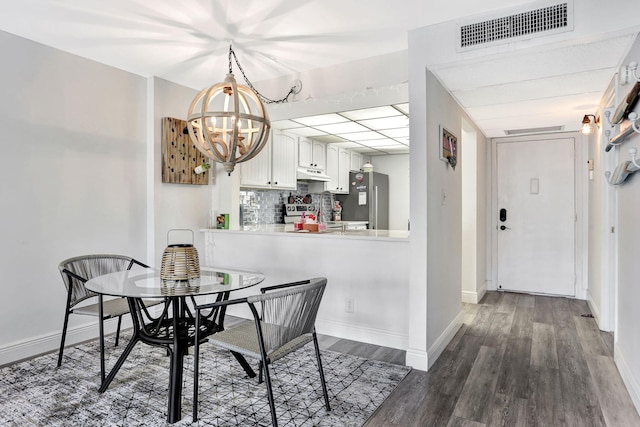 dining room featuring dark hardwood / wood-style flooring and an inviting chandelier