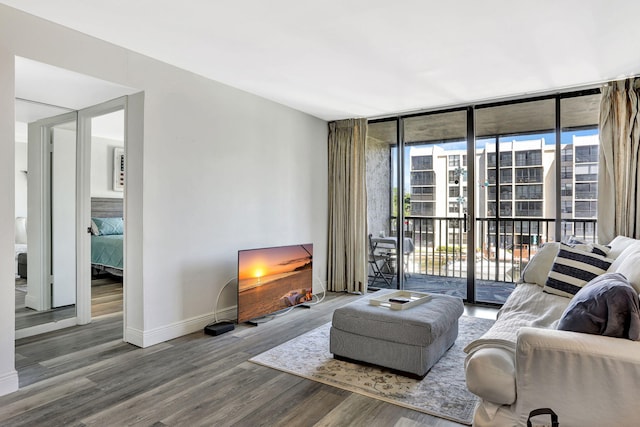 living room with hardwood / wood-style flooring, a wall of windows, and plenty of natural light