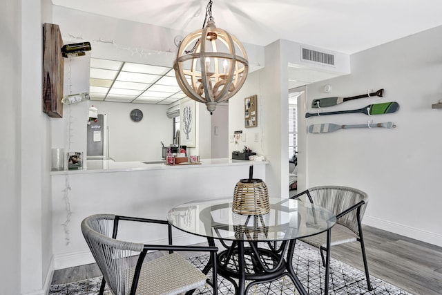 dining room featuring an inviting chandelier, sink, and hardwood / wood-style flooring