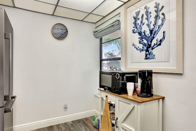 office space with a paneled ceiling and dark hardwood / wood-style flooring