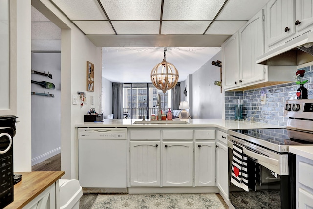 kitchen with sink, dishwasher, hanging light fixtures, electric range, and white cabinets