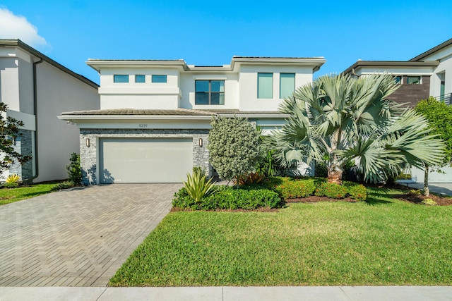 view of front of property with a garage and a front lawn