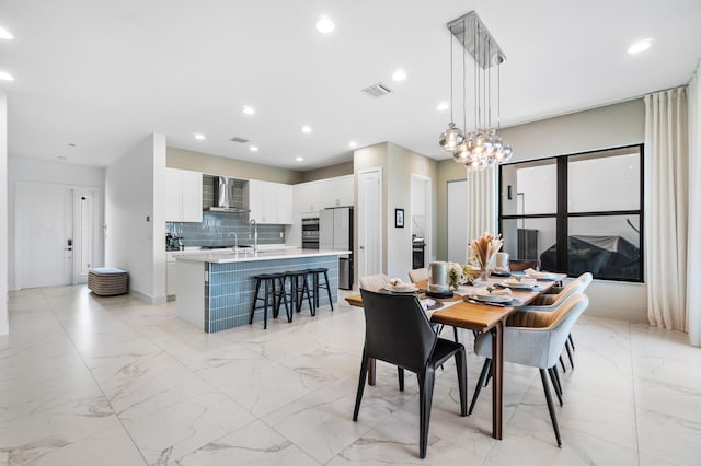 dining space featuring a chandelier and sink