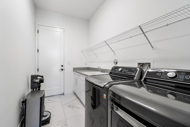 laundry area featuring cabinets, washing machine and clothes dryer, and sink