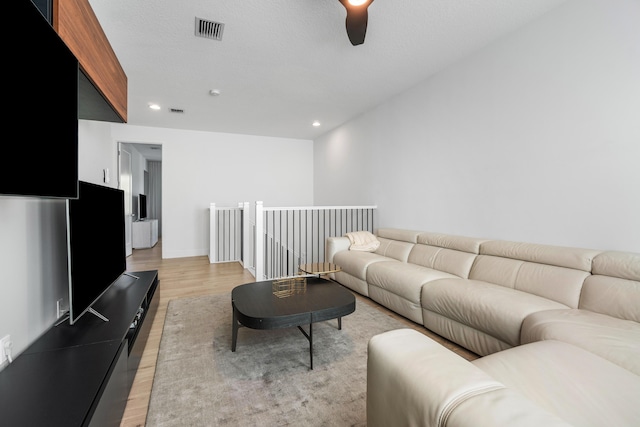 living room with ceiling fan and light wood-type flooring