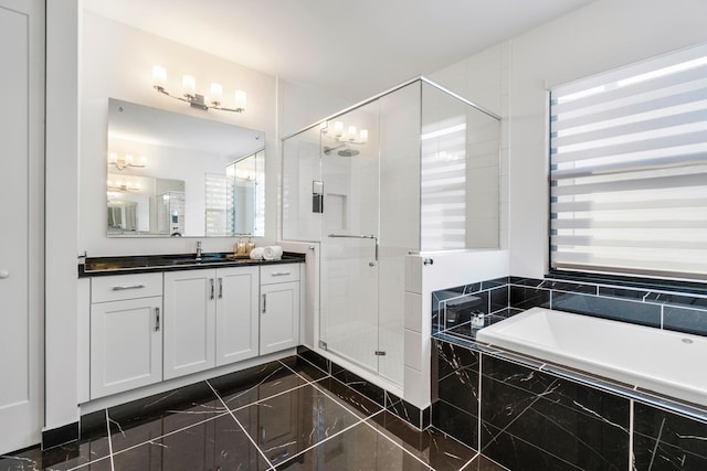 bathroom with independent shower and bath, vanity, a healthy amount of sunlight, and an inviting chandelier