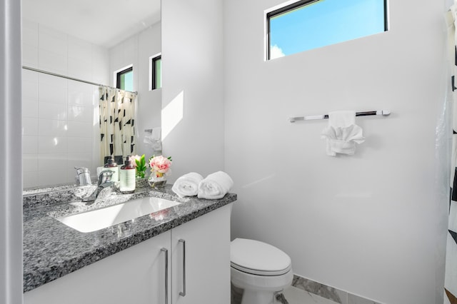 bathroom with vanity, curtained shower, and toilet