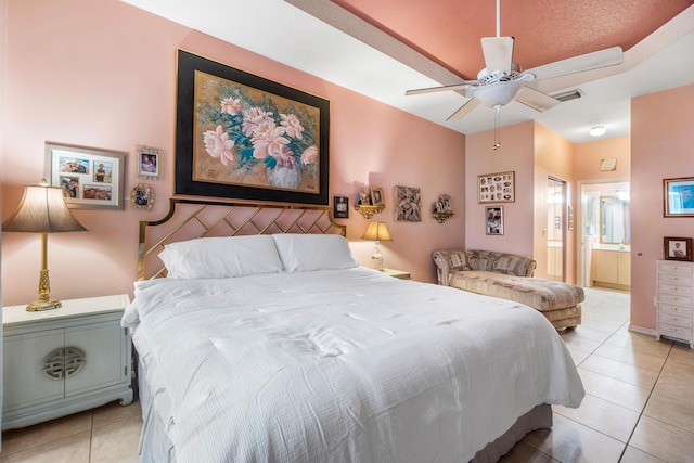 tiled bedroom featuring ceiling fan and ensuite bath