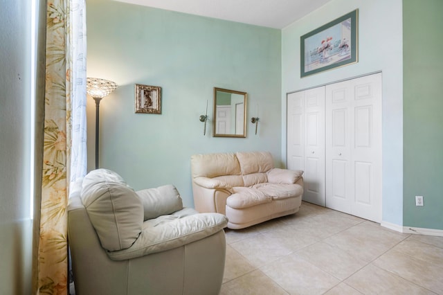 sitting room with light tile patterned floors and a towering ceiling