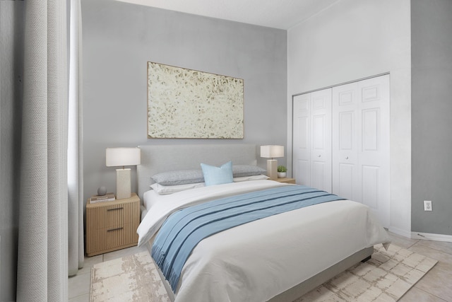 bedroom featuring a high ceiling, a closet, and light tile patterned floors