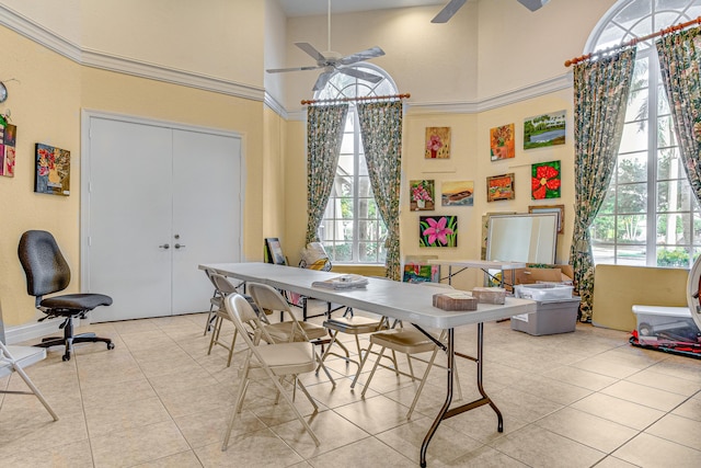 tiled dining room with a high ceiling and ceiling fan