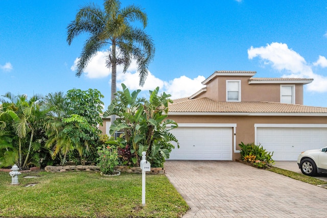 mediterranean / spanish-style house with a garage and a front yard