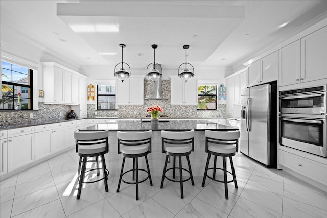 kitchen featuring pendant lighting, appliances with stainless steel finishes, a kitchen island, and a breakfast bar area