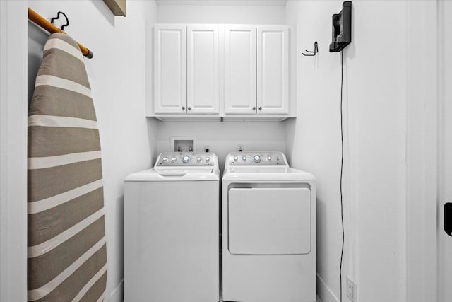 laundry room with cabinets and washing machine and clothes dryer