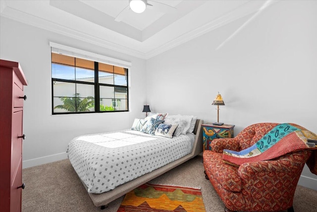 bedroom featuring ornamental molding, carpet, ceiling fan, and a tray ceiling