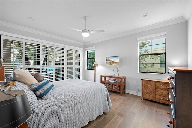 bedroom with multiple windows, crown molding, ceiling fan, and light wood-type flooring