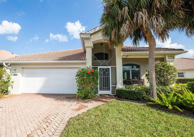 mediterranean / spanish-style house with a garage and a front lawn