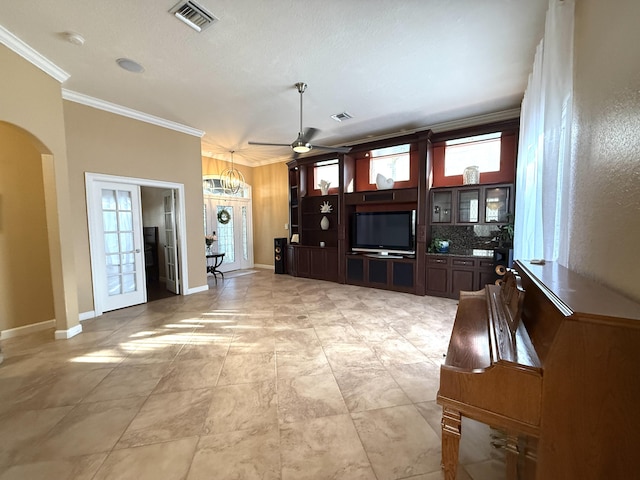 unfurnished living room featuring visible vents, arched walkways, baseboards, and crown molding