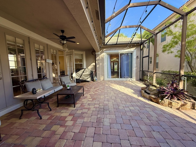 view of patio with glass enclosure and a ceiling fan