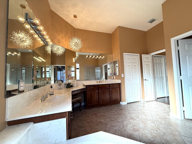 full bathroom with tile patterned flooring, visible vents, baseboards, tiled shower, and vanity