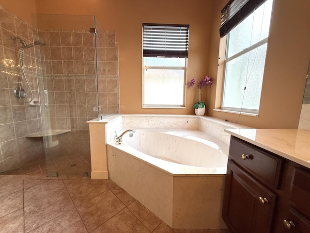 full bathroom featuring tile patterned flooring, a garden tub, vanity, and tiled shower