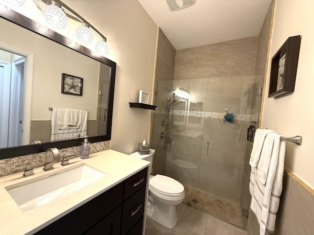 bathroom with visible vents, toilet, a stall shower, a textured ceiling, and vanity