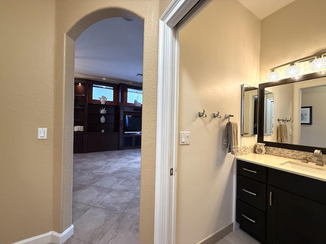 bathroom featuring baseboards, vanity, and a textured wall