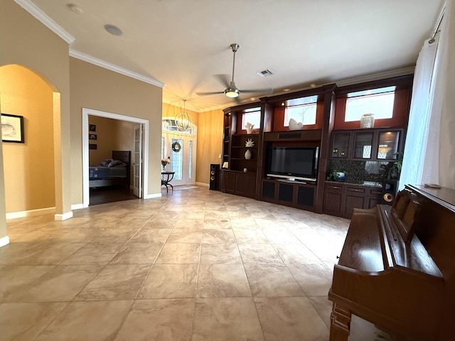 unfurnished living room featuring visible vents, ceiling fan with notable chandelier, arched walkways, crown molding, and baseboards