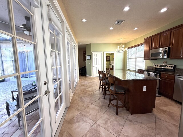 hall featuring a tray ceiling, baseboards, dark wood-type flooring, and visible vents