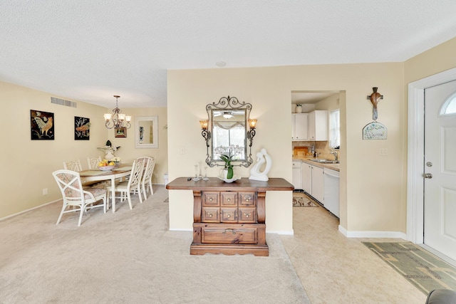 entryway featuring a wealth of natural light, visible vents, a textured ceiling, and a chandelier