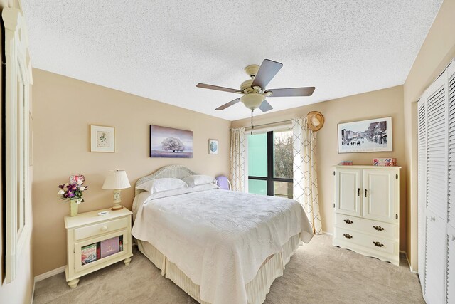 bedroom featuring light carpet, a textured ceiling, and a closet