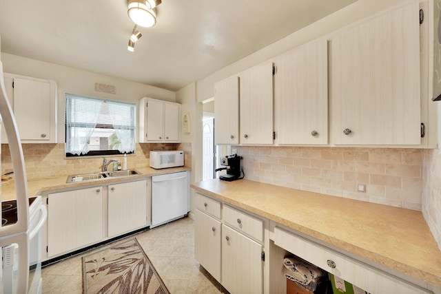 kitchen with white appliances, light tile patterned flooring, light countertops, and a sink