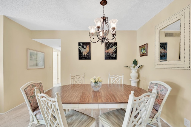 carpeted dining area featuring a notable chandelier, baseboards, visible vents, and a textured ceiling