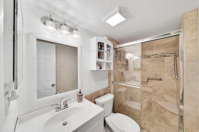 bathroom with vanity, toilet, and a stall shower