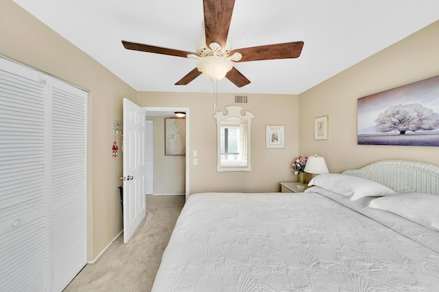 bedroom with visible vents, baseboards, light carpet, a closet, and a ceiling fan