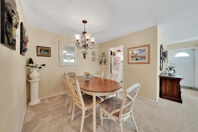 dining room with a textured ceiling, an inviting chandelier, and light carpet