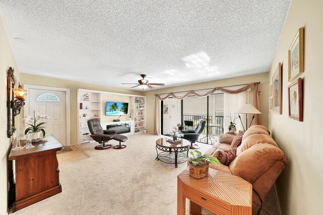 carpeted living area featuring a textured ceiling and ceiling fan