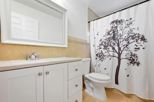 bathroom with tile walls, vanity, tile patterned floors, and toilet