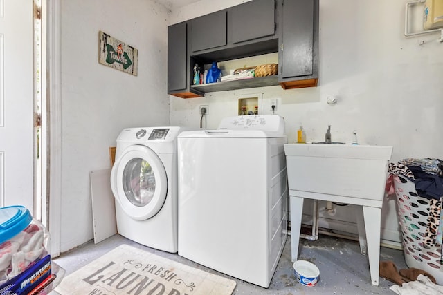 laundry area with independent washer and dryer and cabinets