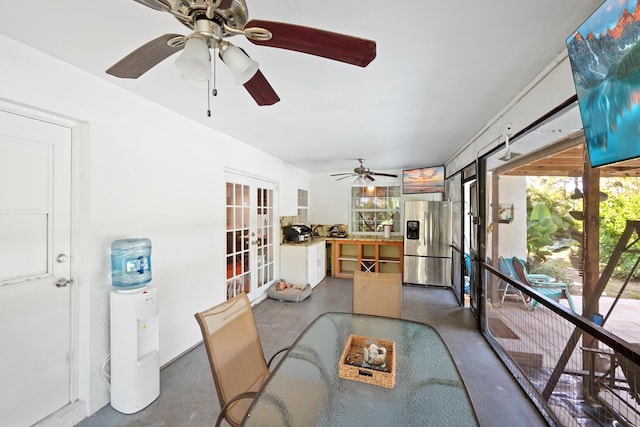 dining area with concrete floors, ceiling fan, and french doors