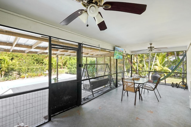 unfurnished sunroom featuring ceiling fan