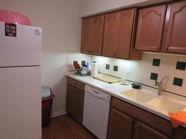 kitchen featuring dark hardwood / wood-style flooring, sink, white appliances, and decorative backsplash