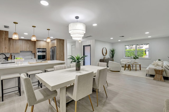 dining area with light wood-style floors, baseboards, visible vents, and recessed lighting