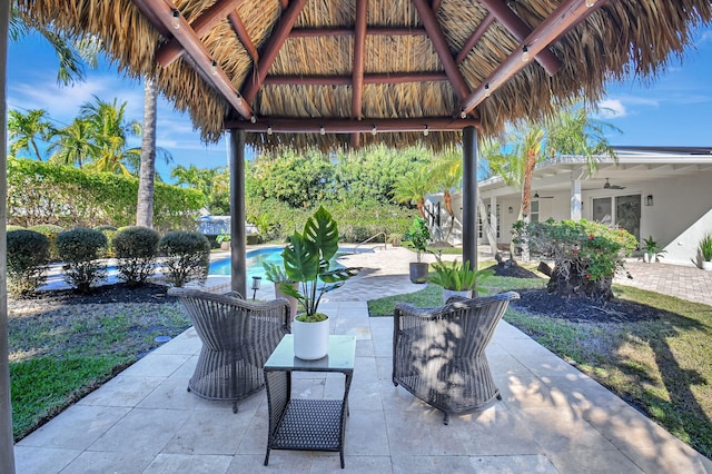 view of patio / terrace with ceiling fan, an outdoor pool, and a gazebo