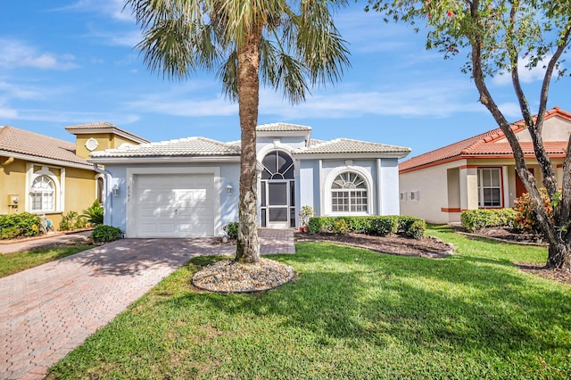 mediterranean / spanish home featuring a garage and a front lawn